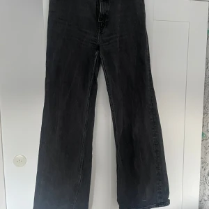 Svarta wide jeans i storlek 28 - Säljer ett par svarta jeans med breda ben och klassisk femficksmodell. Jeansen har en snygg tvättad look och är i en loose fit med hög midja. Perfekta till färgglada tröjor! Modellen Yoko från Monki.