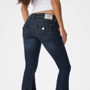 True Religion mörkblå bootcut jeans - Mörkblå low waist bootcut jeans från True Religion. De är i fint skick knappast använda, storlek w26, långa i storleken 💕