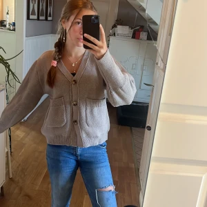 Beige stickad kofta med knappar - Mysig beige stickad kofta med stora knappar framtill och två rejäla fickor. Koftan har en avslappnad passform och långa ärmar, perfekt för lager-på-lager. Enkel att matcha med jeans eller kjol för en chill look. Glömt vart den är köpt men verkligen så mysig kofta💕💕står även ingen storlek i tröjan men skulle tro att den går på både xs,s och M💗💗