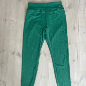 Gröna höga leggings med scrunch från gymshark - Snygga gröna leggings med hög midja och scrunch-detalj bak som framhäver formen. Stretchigt material som sitter tight. Passar M/L