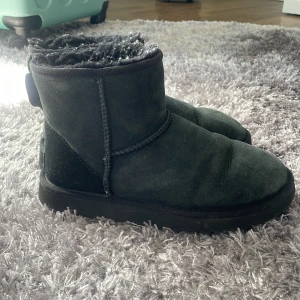 Svarta UGG boots i mocka - Klassiska svarta UGG boots i mjuk mocka med fluffigt foder och rund tå. Skorna har en platt sula och är äkta. Tyvärr har jag inte kvar lådan till de. De är använda sparsamt. Pris kan diskuteras 🤍