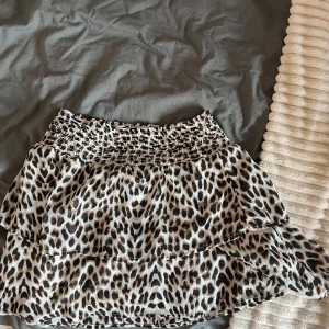 Leopardmönstrad volangkjol - Kort kjol med leopardmönster och dubbla volanger. Resår i midjan för skön passform. Tunt, luftigt material som känns lätt.