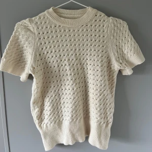 Kräm vit kortärmad stickad tröja - Superfin stickad tröja med korta ärmar och rund hals. Tröjan har ett hålmönster över hela och breda ribbade muddar vid ärmslut. Skriv vid frågor eller fler bilder🙌😇