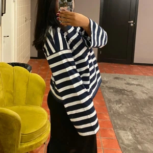 Randig långärmad tröja i marinblått - Säljer en långärmad tröja med breda marinblå och vita ränder. Tröjan har en loose fit och raka ärmar, perfekt för en chill och avslappnad stil. Tillverkad i mjuk bomull som känns skön mot huden. Tjock skön material och perfekt til sommaren nu.