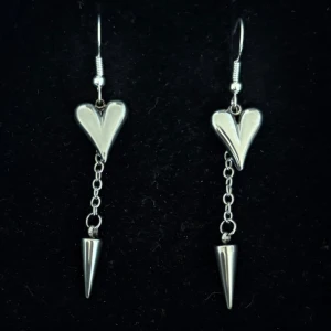 Silvriga örhängen med hjärtan och spikes - Handgjorda och unika silverörhängen 🤩 Öronhängerna är nickelfria och silverpläterade i kirurgiskt stål, resterande av örhänget är i rostfritt stål (ej silverpläterat) 💕🙏 6 cm långa. Alla köp görs via ”KÖP NU” knappen.  💐