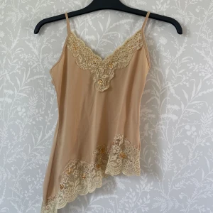 Asymmetrisk 2000s topp med fina spetsdetaljer  - Unik och snygg topp i nyskick! Stretchig så passar xs-m💛den är ljusare i verkligheten!