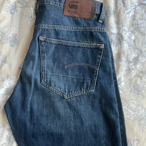 Levi's 501 och G-Star Raw jeans blå - Två par klassiska blå jeans, ett par Levi's 501 med rakt ben och ikonisk läderpatch, samt ett par G-Star Raw med snygga detaljer och mörkblå tvätt. Båda har femficksmodell, normal passform och är tillverkade i slitstark bomullsdenim.