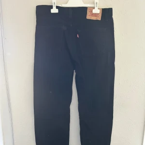 Svarta Levi's 501 jeans straight fit - Svarta Levi's jeans med klassisk rak passform. Ikonisk läderpatch bak i midjan. Perfekta för en clean och tidlös look. Nypris 1000kr. W33 L34