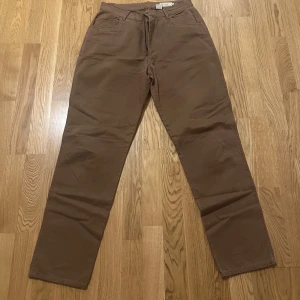 Bruna raka byxor från Hennes  - Snygga bruna byxor från Hennes Collection i rak modell. Byxorna har klassisk femficksdesign, normal passform och är tillverkade i 100% bomull. Perfekta för en chill och stilren look.