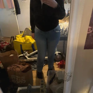 Ljusblå jeansbyxor med normal passform - Säljer ett par ljusblå jeansbyxor med klassisk femficksdesign och normal passform. Byxorna har hög midja och raka ben. Perfekta för dig som gillar en enkel och stilren look. Passar till det mesta och är lätta att matcha.