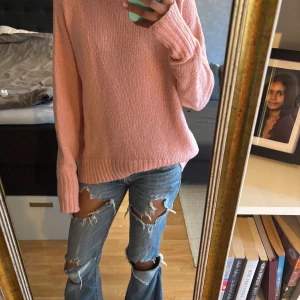 Rosa stickad polotröja från 157 - Mysig rosa stickad polotröja från 157. Tröjan har en hög polokrage, lång ärm och avslappnad passform. 