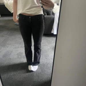 Svarta jeansbyxor med normal passform - Svarta jeansbyxor med klassisk femficksdesign och normal passform. Byxorna har knapp och dragkedja framtill samt raka ben. Perfekta för en stilren och enkel look.