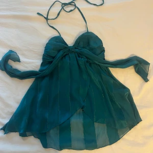 Turkos halterneck topp i med guldiga streck - Turkos fint vintage topp med fina guldiga detaljen!! Märket är kookaii är är i väldigt fint skön material!! Storlek s och tyget är inte väldigt stretchig❤️Använd köp nu funktionen🌺