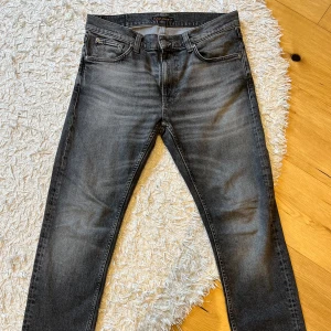 Gråa Nudie jeans - Säljer dessa riktigt snygga gråa jeans från nudie. Byxorna är i mycket fint skick och är knappt använda. Säljer dom för att de inte är min storlek. Nypris 1699, mitt pris 799. Storlek 31/30. Pris kan diskuteras, hör av er!