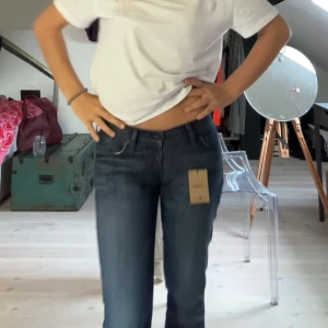 Mörkblå jeans från 7 For All Mankind - Säljer ett par mörkblå jeans från 7 For All Mankind med lågmidja och straightleg. Köpte på sellpy men använde aldrig. Står 27 som storlek men skulle säga de är 36/38 som jeans storlek  