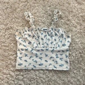 Fin topp - Supersöt vit linnetopp med små blå blommor och volangprydda axelband. Tvättas innan postning😽❤️❤️
