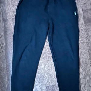 Svarta mjukisbyxor från Polo Ralph Lauren - Svarta mjukisbyxor från Polo Ralph Lauren med klassisk broderad logga framtill. Byxorna har elastisk midja och en bakficka. Perfekta för en avslappnad stil.