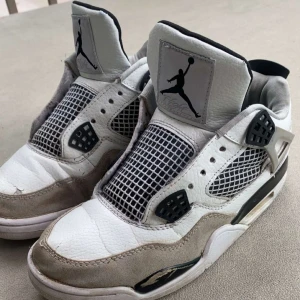 Jordan 4s  - Säljer ett par klassiska Nike Air Jordans i vitt och grått med svarta detaljer. Skorna har nätpaneler på sidorna och tungan, samt den ikoniska Jumpman-loggan på plösen. Perfekta för dig som gillar streetwear och sneakerskultur.