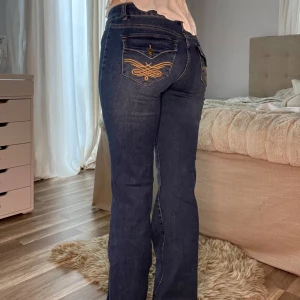 Blå bootcut jeans från Madlady - Säljer ett par blå bootcut jeans från Madlady med dekorativa sömmar och broderade fickor bak. Jeansen är low waist. Perfekta för dig som gillar en retroinspirerad look💕Byxorna är oanvända. (Jag är 1,69cm) EU36/Reg motsvarar S/165-170cm
