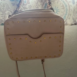 Rosa handväska  - Säljer denna coola handväska som jag köpt begagnad! Den är rosa och har förstås lite defekter men superfin och trendig annars! En lite valentino liknande väska!