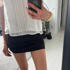 Svart ribbad minikjol - Säljer en svart ribbad minikjol med tight passform. Kjolen är lång, men jag brukar  ”skrynkla” ihop den så att den blir kortare och lågmidjad! Den har en enkel, stilren design utan synligare detaljer. 💓eftersom den är stretchig passar den XXS-S