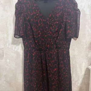 Klänning  - Svart klänning med rött leopardmönster från Lindex. Passar bra till fest med också vardagligt ❤️