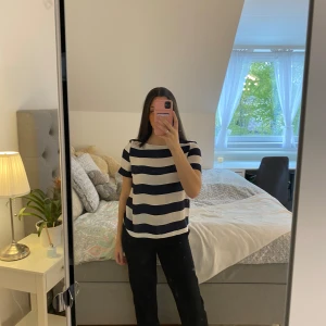 Randig topp från Holly & Whyte - Säljer en snygg topp från Holly & Whyte i marinblått och vitt med breda horisontella ränder. Toppen har korta ärmar, rund halsringning och dragkedja bak. Perfekt till jeans eller kjol för en fräsch look.