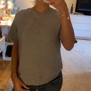 Grå stickad kortärmad tröja - Mysig grå stickad tröja med korta ärmar och rund halsringning