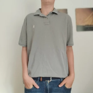 Ralph Lauren piké  - Grå Ralph Lauren piké i bra skick. Storlek L men passar M. Några små hål på ryggen. Kolla profilen för mer Ralph Lauren kläder 