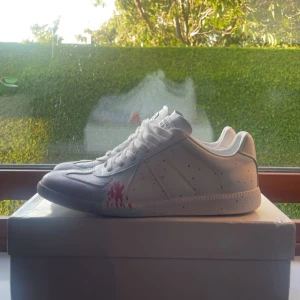 Maison margiela paint splatter - Säljer nu dessa riktigt snygga och unika skor från Maison margiela 🤩 Utmärkt skick, 9/10. Box tillkommer! 📦 Storlek 44. Färgen är vit med ljusblå och röd paint splatter. Hör av er vid funderingar ‼️