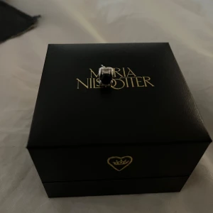Silverörhänge Maria Nilsdotter med svart sten - Ett fint örhänge från Maria Nilsdotter som inte finns kvar på hemsidan 🥰 Beviset på att den är äkta är att det står dotter på den ❤️ Säljer billigt för där man sätter i örhänget är lite krokigt ❤️PRIS KAN DISKUTERAS 