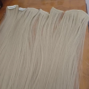 Blonda clip-on löshår 60 cm - Säljer ett set med blonda clip-on löshår, ca 60 cm långa. Håret är rakt och har en kall, ljusblond nyans. Fästena är vita clips i metall som enkelt sätts fast i håret. Perfekt för dig som vill ha längre och fylligare hår på nolltid. En 4a, två 3or och tre 2or. Köpt på vinted så oklart vart de är ifrån,  oanvänt då det inte blev som tänkt  