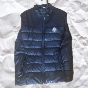 Svart dunväst från Moncler - Snygg och sällsynt svart dunväst från Moncler. Ja jackan är 100% äkta, med broderad logga på bröstet och stor Moncler-text på ryggen. Västen har quiltad design, dragkedja framtill och två fickor med dragkedja.  Jackan har en svart camo design som bara syns från vissa vinklar. Jackan är använd fåtal gånger under denna höst. Mitt pris JUST NU är 900kr. Går att pruta lite vid snabbt köp. 