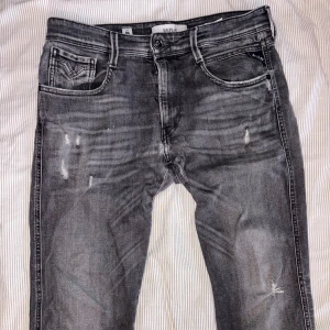 Replay Anbass grå jeans slim fit - Replay Anbass 5 years wash model. Säljer för att de ej kommer till användning så mycket. Modellen har slitningar och produceras inte längre. Byxorna har ett hål i skrevet som enkelt kan fixa med en nål och tråd.