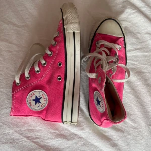 Rosa converse🩷 - Säljer ett par klassiska Converse All Star high tops i en riktigt poppig rosa färg. Skorna har vit sula, vita snören och den ikoniska loggan på sidan. Köp nu går bra elle skriv om du har frågor!🩷