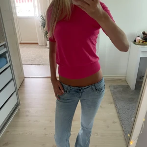 Rosa stickad T-shirt - Superfin rosa tröja från Zara med korta ärmar och rund hals. Modellen är figurnära med bredare ribbad kant nedtill som ger en snygg passform. Perfekt till jeans eller kjol för en färgstark look.