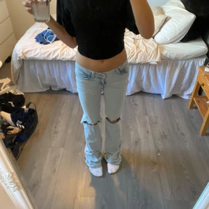 ljusblå nelly jeans - Säljer ett par ljusblå bootcut jeans med slitna knän och rosa detaljer från nelly. Jeansen har klassisk femficksdesign och broderade bakfickor med rosa vågmönster. det är stl 32 i dem. de har en liten defekt längst ner på benet (se sista bild) men inget som syns när man har de på sig.🩷