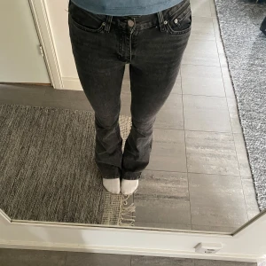 Svarta bootcut jeans - Säljer ett par svarta bootcut jeans med klassisk femficksdesign och snygg tvätt. Jeansen har normal passform och är tillverkade i ett mjukt denimtyg som sitter skönt hela dagen.