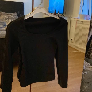 Svart långärmad topp med rund hals - En stilren svart långärmad topp med rundad halsringning.är. Jätte mjukt material säljer pågrund av att den e för liten köpt för 90 använt fåtal ggr