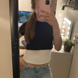 Svart croppad t-shirt - Säljer en svart croppad t-shirt med kort ärm. Perfekt kombo för en trendig och avslappnad look. T-shirten är enkel och stilren medan tubtoppen ger en snygg kontrast. Passar dig som gillar lager på lager-stil. Säljer tyvärr inte vita linnet under men kan vara en väldigt snygg detalj! Har inte använd någon gång. Skriv gärna om du har frågor! 💗❣️