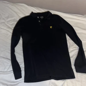 Svart långärmad pikétröja Lyle & Scott - Svart långärmad pikétröja från Lyle & Scott. Har använt 2-3 gånger