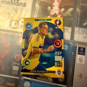 John Guidetti - Sverige (Rising Star) - Samlarbild på fotbollsspelaren John Guidetti i Sveriges landslagströja. Perfekt för dig som älskar fotboll och vill utöka din samling med en Rising Star från Sverige. 