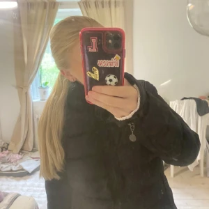 Svart dunjacka från Moncler - Säljer en svart dunjacka från Moncler med hög krage och dragkedja framtill. Jackan har lång ärm och Moncler-logga på ena ärmen. Klassisk pufferstil som håller värmen under kalla dagar.