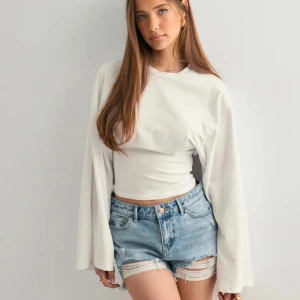 Vit croppad långärmad tröja - Vit långärmad tröja från Nelly!! Helt ny 💕 säljer för 199 kr ex. Frakt 🩷