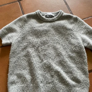 Grå stickad t shirt från Zara - Mysig grå stickad tröja från Zara i storlek S. Materialet är fluffigt och ger en soft vibe. Den är noprig men fin ❤️