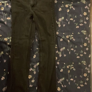 Svarta raka jeans - Säljer ett par svarta jeans med klassisk femficksdesign och raka ben. Jeansen har normal passform och är tillverkade i ett mjukt bomullsmaterial med lite stretch. Perfekta för dig som gillar en enkel och stilren look.