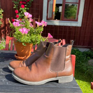 Bruna läderstövlar med dragkedja - Snygga bruna läderstövlar i skinn med en klassisk design. De har en dragkedja på sidan. Perfekta för höst och vinter, passar till många olika outfits.