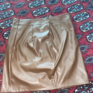 Brun skinnkjol i kort modell - Brun läderkjol i storlek 36 – töjbar och i fint skick  Säljer denna fina bruna läderkjol då den tyvärr har blivit för stor för mig. Den är i storlek 36 och har en viss töjbarhet vilket gör den bekväm att bära. Älskar verkligen kjolen – den passar perfekt både till vardags och till fest.  Pris: 40 kr   Hör gärna av dig vid intresse!