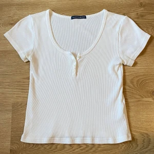 vit ribbad topp / t-shirt (brandy melville) - säljer en söt vit ribbad topp från brandy melville. 🤍🫶🏻 (ord. pris: 250kr)