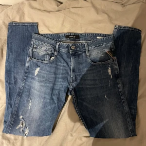 Blå jeans från Replay - Snygga blå jeans från Replay model Anbass med slitna detaljer.     10/10 skick med inga defekter. Storleken är 32/34, priset är diskuterbart vid snabb affär.            Hör gärna av er vid fundering!
